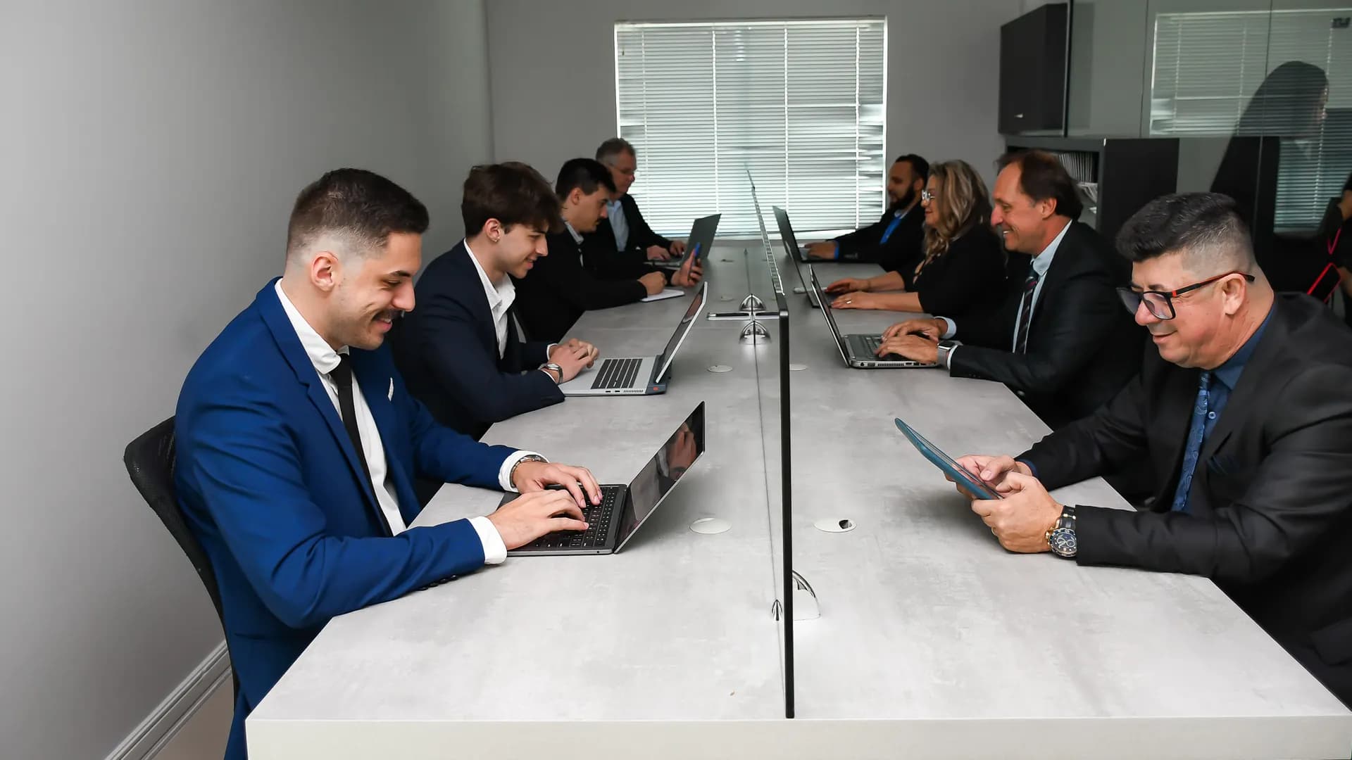 Equipe Mercedes Imóveis no escritório central em Itajaí, em mesa de trabalho conjunta